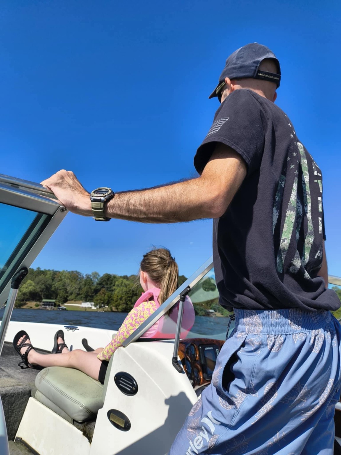 Gary at the helm of a boat on a sunny day