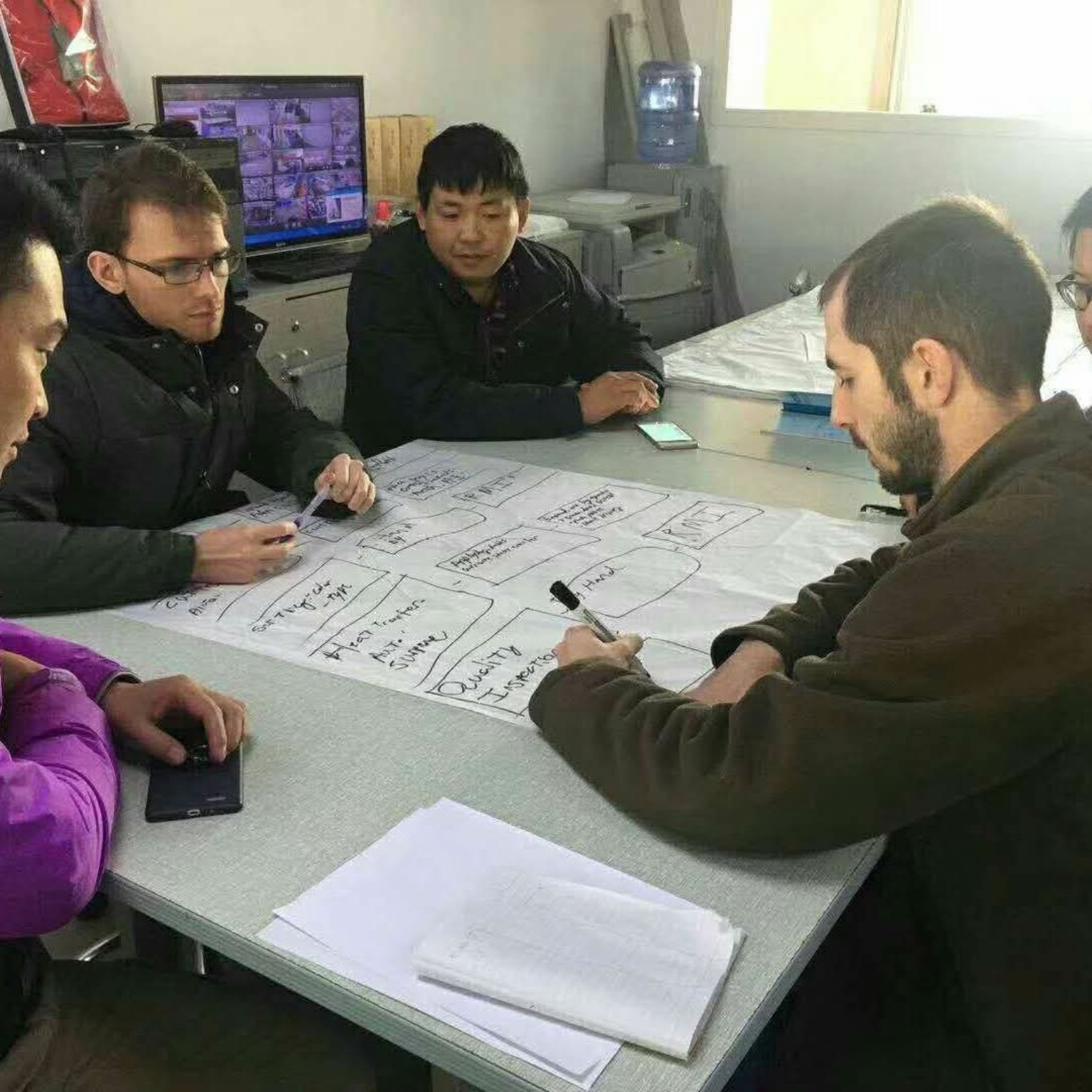 Gary collaborating with a group around a table covered in planning notes