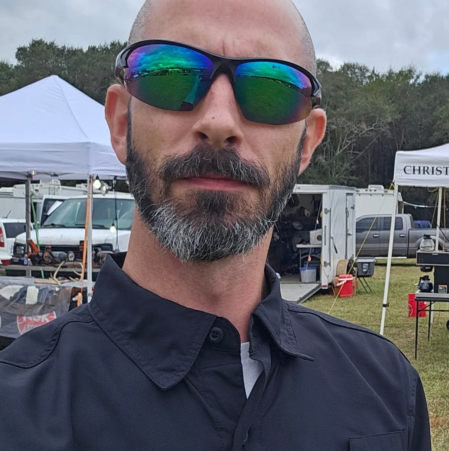 Gary outdoors with event tents and equipment in the background