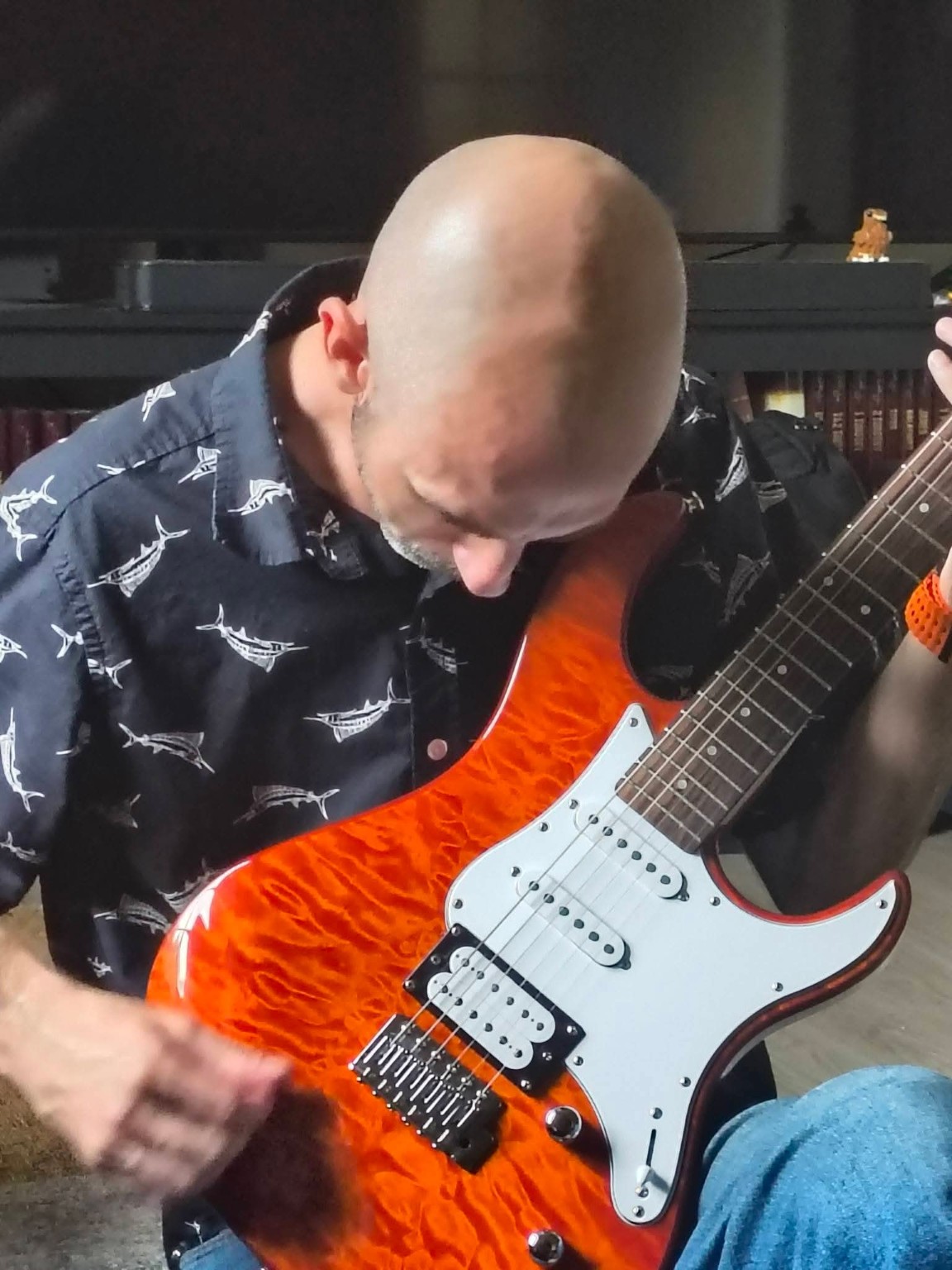 Gary playing an orange electric guitar